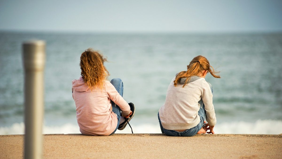 浜辺に座る二人の女性